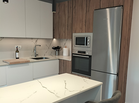 Cocina de muestra con mobiliario de madera y encimera de mármol blanco en tienda Art'Decco