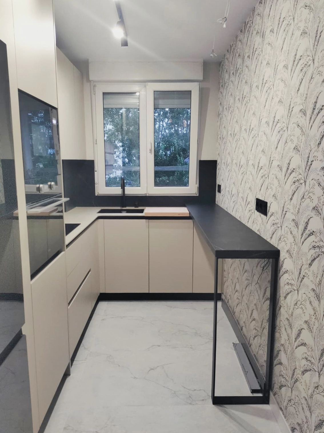 Cocina reformada con isla central en un proyecto de Santander